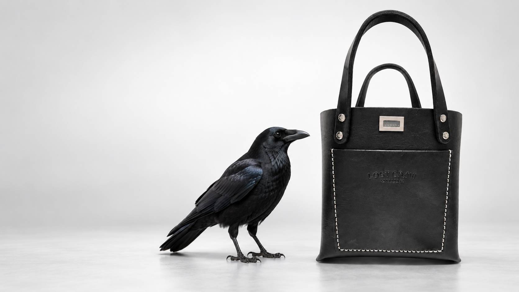Black Lost Crow leather tote beside a crow